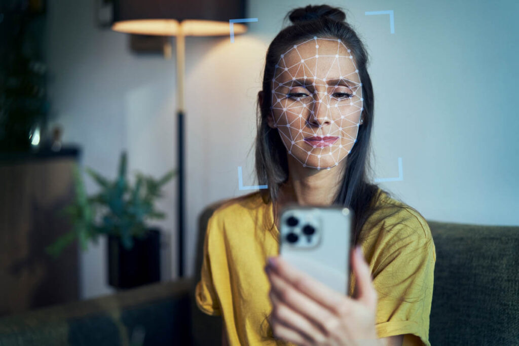 woman using facial recognition on smartphone indoors