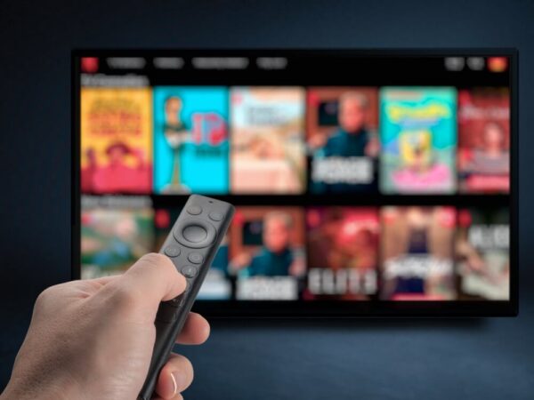 hand holding remote control pointing at streaming TV