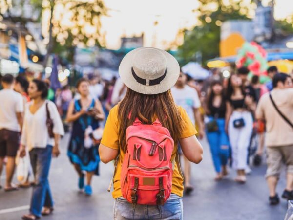 traveler with backpack walking crowded outdoor market