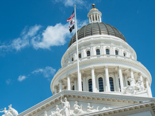 California state capitol building dome American flag blue sky