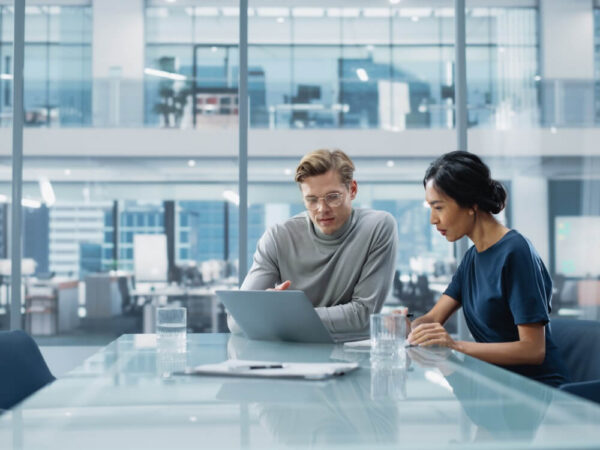 two colleagues reviewing data on a laptop in an office