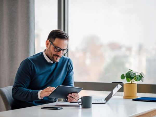 government employee reviewing tablet device office window