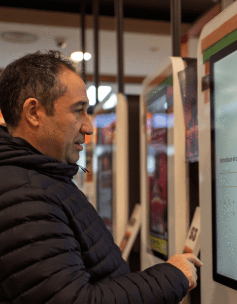 man using self service kiosk touchscreen