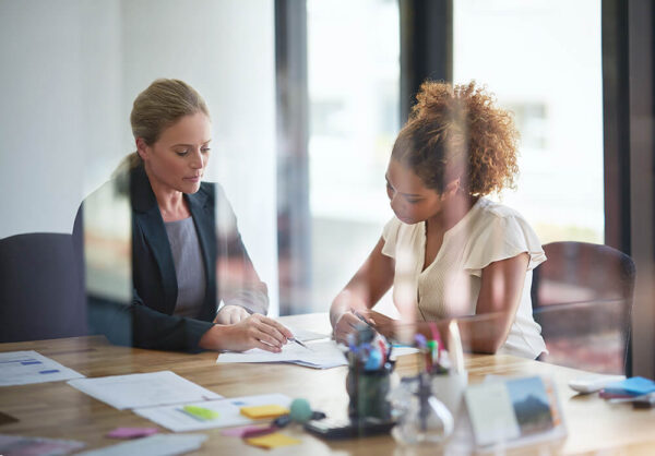 two people reviewing paperwork at office table