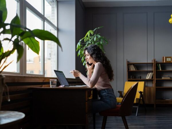 woman phone laptop home office